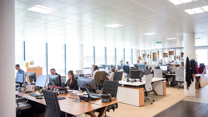 People working at desks in an open-plan office. Photo by Arlington Research on Unsplash.