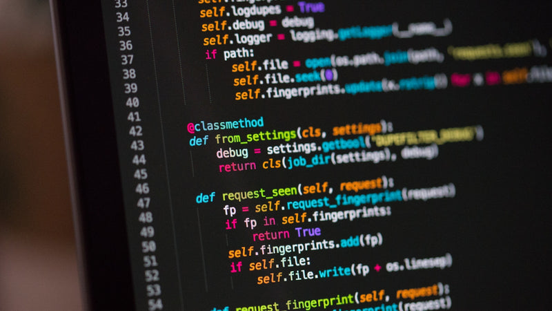 Lines of Python code on a dark screen. Photo by Chris Ried on Unsplash.