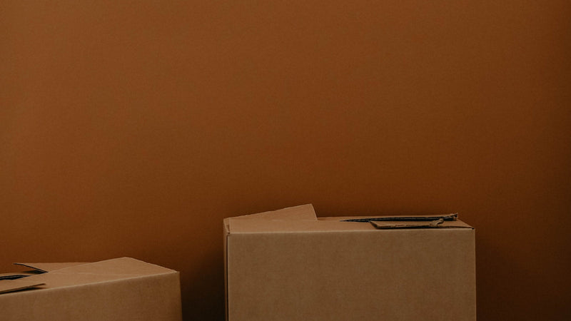 Stack of brown cardboard moving boxes. Photo by Kadarius Seegars on Unsplash.