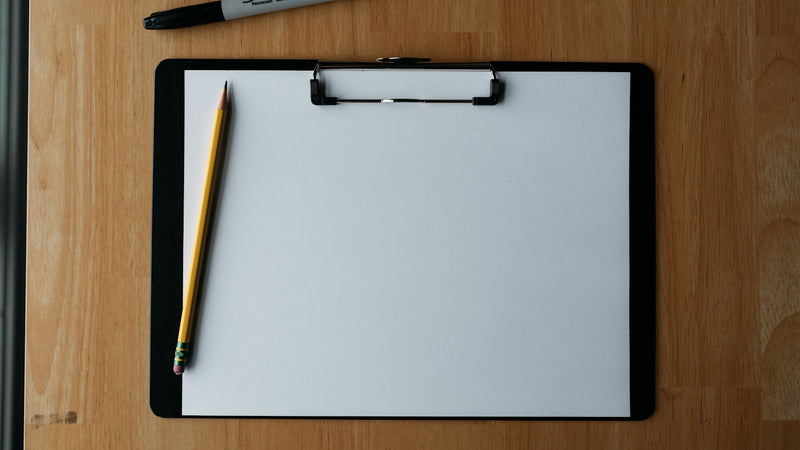 Blank clipboard with a pencil on a wooden desk. Photo by Kelly Sikkema on Unsplash.