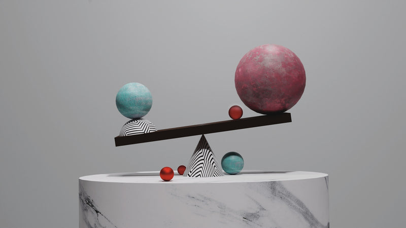 Balance scale with spheres on a marble pedestal. Photo by Myles Bloomfield on Unsplash.